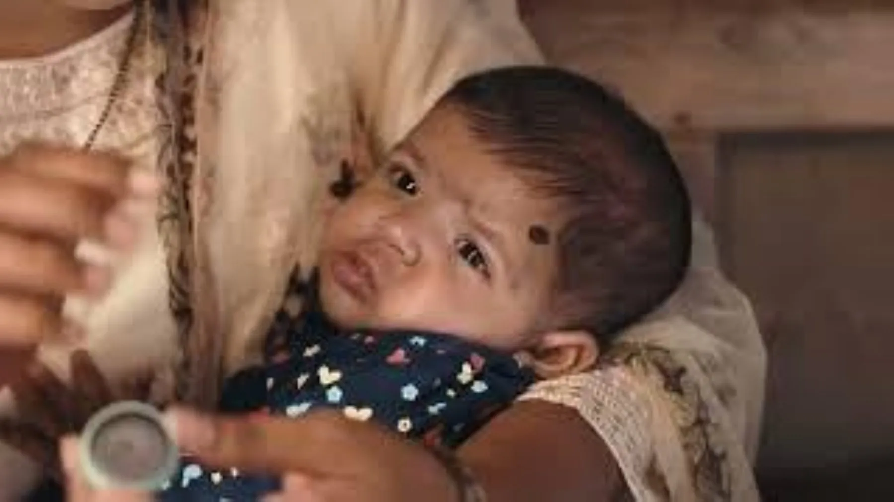 An infant wearing the Arogya Bindu kohl dot